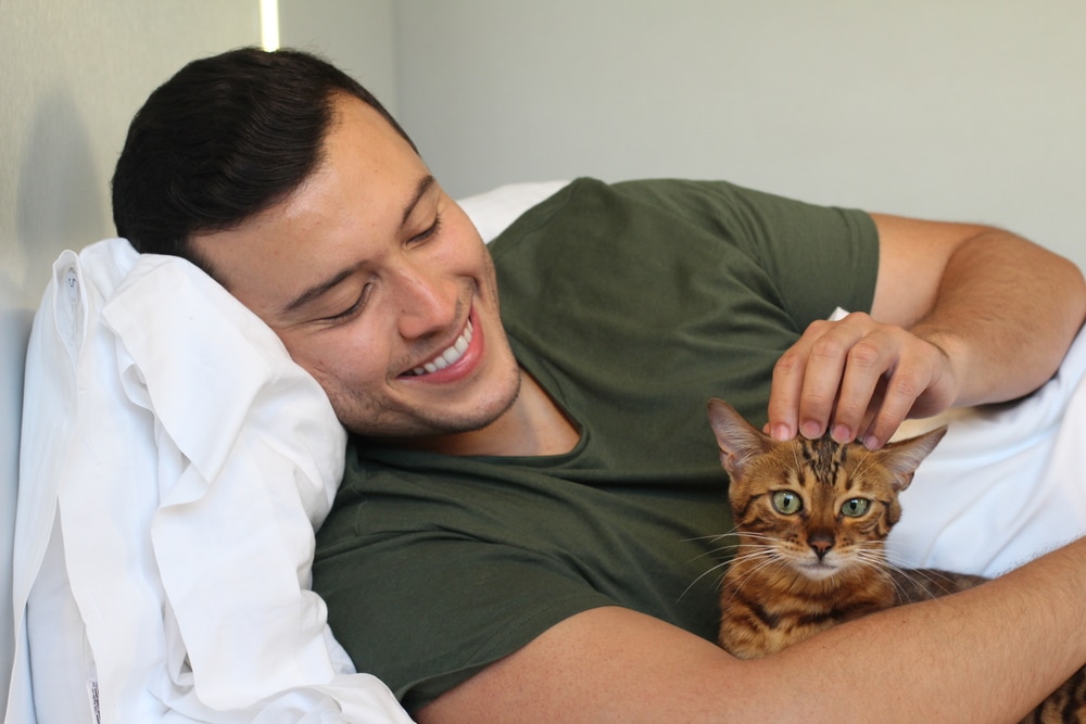 scratching the head of his cat