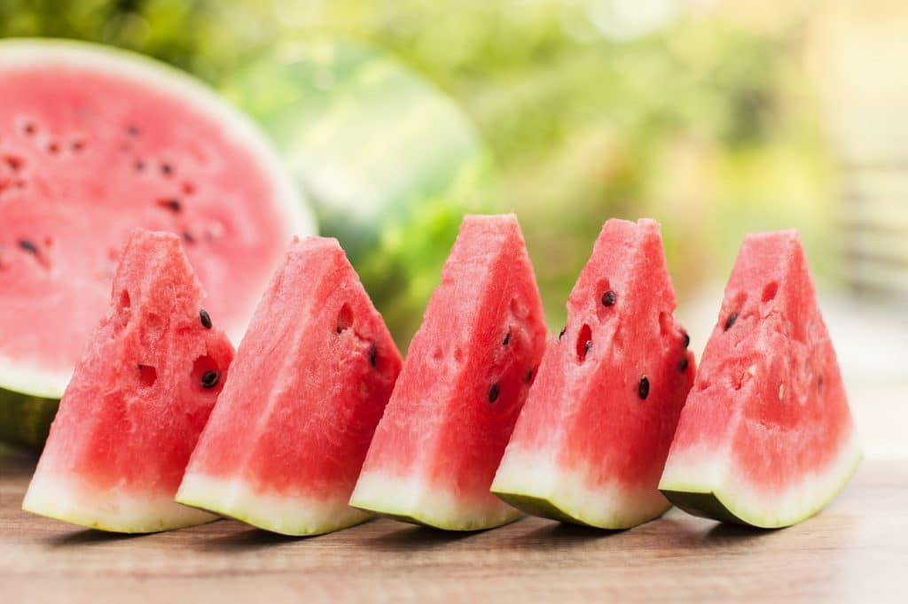 Delicious refreshing watermelon slices on the table outdoors - shallow depth